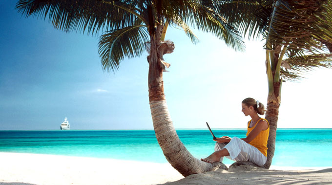 Woman on Tropical Beach with Laptop Computer